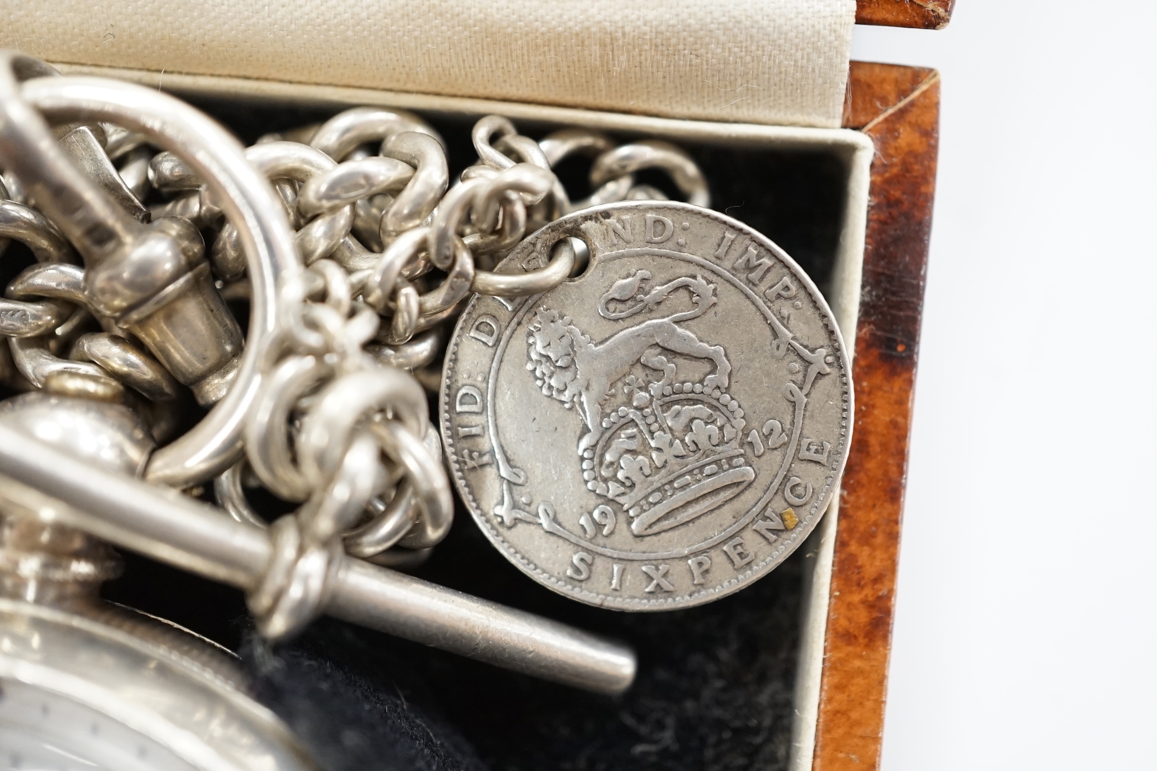 A Swiss 935 white metal open faces keyless pocket watch, with Roman dial and subsidiary second, on a silver albert.